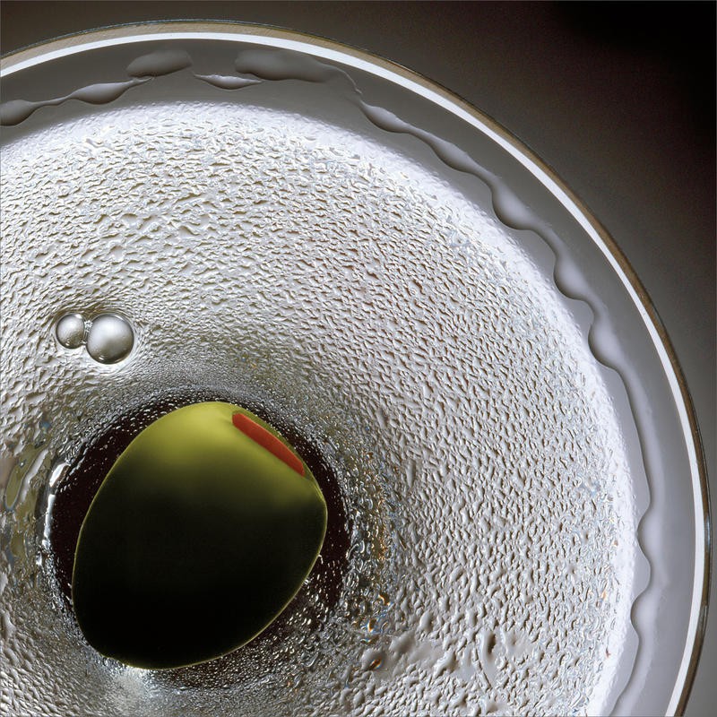 Barry Seidmann, SHAKEN III (Cocktail, Cocktailglas, Olive, Martini, Aperitif, Esszimmer, Bar, Gastronomie, Fotokunst, Nahaufnahme, Wunschgröße, bunt)