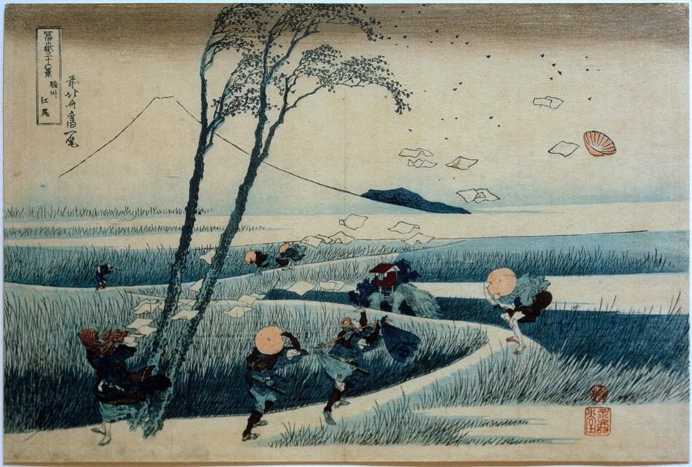 Katsushika Hokusai, Ejiri in der Provinz Suruga (Gebirge,Kopfbedeckung,Kunst,Landschaft,Mann,Meteorologie,Völkerkunde,Wetter,Japanische Kunst,Hut,Baum,Wind,Weg,Schilf,Sumpf,Fliegen,Ansicht,Berg,Bücken,Laubbaum,Land Und Leute,Sturm,Signatur,Damm)