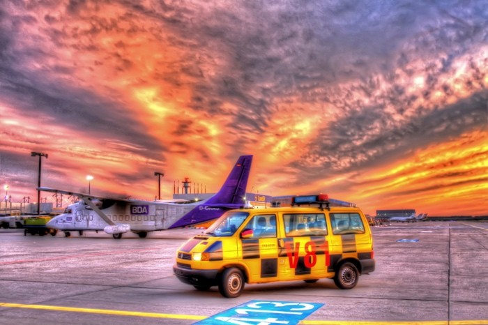 Hady Khandani, HDR - FOLLOW ME ON CARGO APRON UNDER BURNING SKIES (Flughafen, Flugzeug, Rollfeld, Wolken, Lotse, Himmel, Sonnenuntergang, Hadyphoto, Wunschgröße, Fotogkunst, Wohnzimmer, Treppenhaus, bunt)