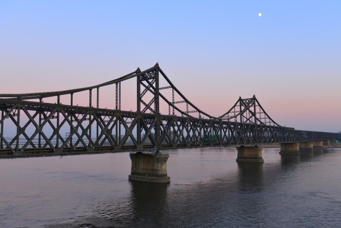 Hady Khandani, SINO-KOREAN FRIENDSHIP BRIDGE OVER YALU RIVER BETWEEN CHINA AND NORTH KOREA - DANDONG 2 (Yalu, Fluss, Brücke, Freundschaftsbrücke, Bauwerk, Konstruktion, Dandong, China, Nordkorea, Fotokunst, Wohnzimmer, Treppenhaus,  Wunschgröße, bunt)