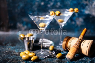 Hoda Bogdan, Martini cocktail drink with olives garnish and tools on rusty background (martini, cocktail, wodka, glas, gin, cosmopolitan, trinken, aperitif, entwerfen, blau, classic, wasser, dekoration, kalt, club, spiegelkugel, disko, bar, getränke, clubbing, oliven, barkeeper, restaurant, feier, sommer, alkohol, wein, schwarz, grau, ei)