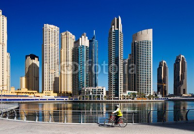 Sophie James, A cyclist cycles the Marina walk, Dubai Marina and JBR (arabe, arabien, arabisch, architektur, strand, bike, blau, boot, gebäude, gebäude, stadt, stadtlandschaft, konstruktion, altersgenosse, fahrradfahrer, zyklus, tage, dubai, abenddämmerung, ost, emirate, gut, abend, äusseres, futuristisch, hochhau)