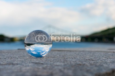 bychykhin, Glass transparent ball on bridge background and grainy surface (durchsichtig, ball, glas, perlen, kristalle, klar, kugel, sphäre, blase, sommer, textur, marmor, meditation, wasser, konzentration, blau, erdball, flüssigkeit, abstrakt, haltung, magisch, perle, licht, konzept, backgrounds, symbol, abbildung, haltun)