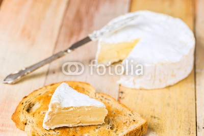 -Marcus-, Camembert cheese with cut wedge on toasted bread slice and vinta (vorspeisen, board, brot, brie, camembert, käse, kreis, close-up, gemeiner, sahnig, schnitt, käserei, deli, köstlich, häusliche, essen, französisch, kopf, foodie, messer, niemand, objekt, figur, plank, erzeugnis, runde, rustikal, slice, imbiss, weic)