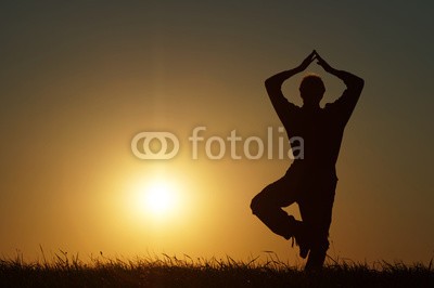 am, Silhouette of a man in a position Vrikshasana at exercising yoga on a grassy horizon at sunset. (silhouette, skyline, leute, körper, person, mann, sonne, sunlight, sonnenuntergänge, sonnenschein, sonnenuntergänge, sunrise, sonnenstrahl, sun rays, yoga, asana, entspannung, frieden, balance, meditation, konzentration, spiritualität, geist, seelisc)