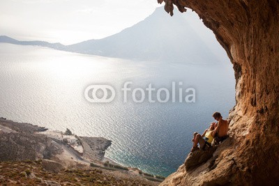 Andrey Bandurenko, Young couple of rock climbers having a rest, Kalymnos, Greece (paar, bergsteiger, entspannen, fels, meer, griechenland, romantisch, liebe, 2, felsen, klettern, jung, klettern, berg, extrem, wasser, natur, landschaft, mädchen, frau, mann, cave, draußen, insel, guy, natürlich, betätigung, anblick, sitzend, erwachse)