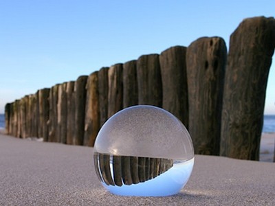 Gerhard Rossmeissl, Kugel im Sand (Landschaft,  Kugel, Glaskugel, Meer, Strand, Sand, Pfosten, Wellenbrecher, Reflexion, Spiegelung, Nordsee, Wellness, Entspannung, Badezimmer, Schlafzimmer,Fotokunst, Arztpraxis, zeitgenössisch, bunt)