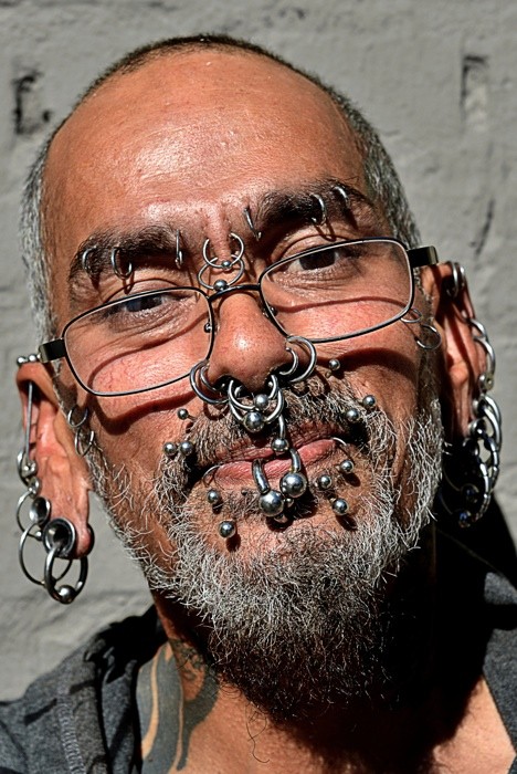 Hady Khandani, THE PIERCED MAN PORTRAIT (Piercings, Nasenringe, Ohringe, Lippenpiercing, Nasenpiercing, Augenbrauenpiering, Gesicht, Mann, Portrait, Punk, Fotografie, Jugendzimmer, Treppenhaus, bunt)