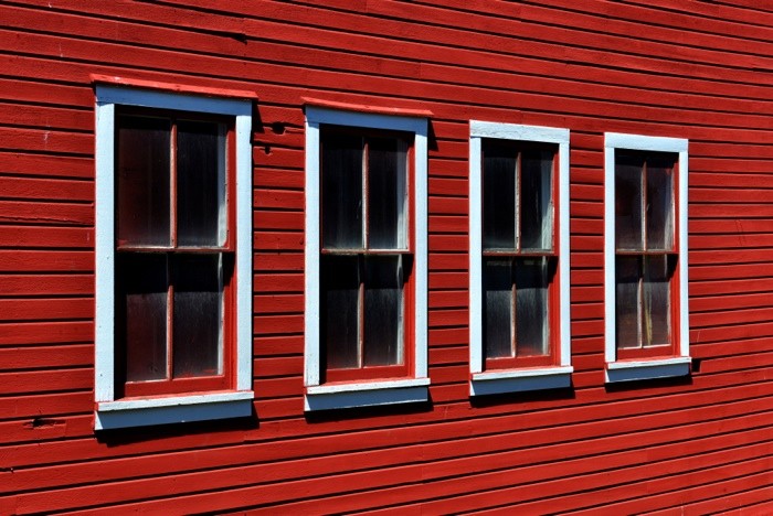 Hady Khandani, FOUR WINDOWS ON A RED WALL (Fassade, Hausfassade, Holzhaus, Fenster,  Wunschgröße, Fotografie, Treppenhaus, Wohnzimmer, rot)