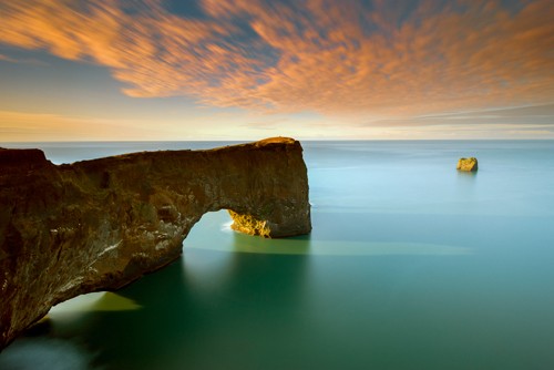 Arnaud Bertrande, Dyrholaey (Felsenbrücke, Halbinsel, Island, Fotokunst, Modern, Landschaft, Meer, Meeresbrise, Horizont,  Wasser, Himmel, Sonnenlicht, Wolken, Wohnzimmer, Badezimmer, Schlafzimmer, Wunschgröße, bunt)