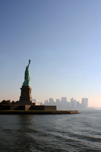 Aurélien Terrible, Liberty leading the City (Freiheitsstatue, Skulptur, Wahrzeichen, USA, Skyline,  Architektur, Hochhäuser, Sonnenlicht, Dunst, Wunschgröße, Büro, Fotokunst, Wohnzimmer, bunt)