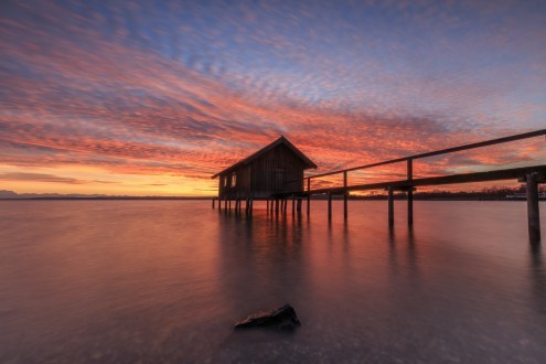 Markus Scholz, Sonnenuntergang am Ammersee (Steg, Bootshaus, Bergsee, Natur, Bayern, Deutschland, Sonnenuntergang, Stille, Entspannung, Ruhe, Einsamkeit, Landschaftsfotografie, Wohnzimmer, Treppenhaus, Wunschgröße, bunt)