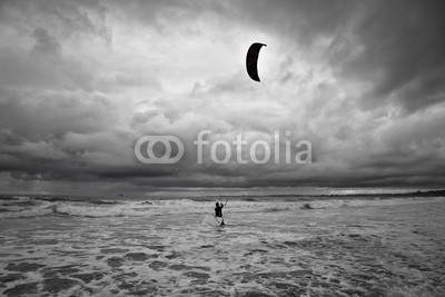 Zai Aragon, Kitesurfer gets in the water during a storm. (aktion, strand, schwarzweiß, mutig, wolken, bewölkt, schaum, grau, drachen, kitesurfen, ozean, bewölkt, natur, meer, seelandschaft, seeküste, seaside, küste, sport, sturm, wassersport, welle, wetter, windig, winte)