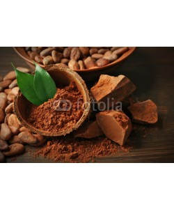Africa Studio, Bowl with aromatic cocoa powder and green leaf on wooden background, close up