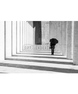 nikhg, Donna con ombrello in un corridoio porticato in bianco e nero