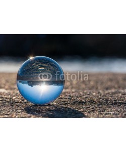 bychykhin, Glass transparent ball on dark background and grainy surface.