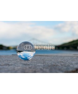 bychykhin, Glass transparent ball on bridge background and grainy surface