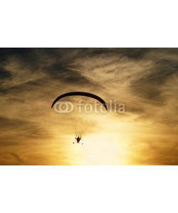 am, Paragliding at sunset. Silhouette against a background a cloudy sky colors the sunset.