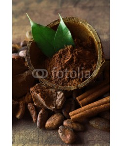 Africa Studio, Bowl with aromatic cocoa powder and green leaf on wooden background, close up