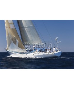 biker3, Side view of a group of crew members sitting on the side of a sailboat in the ocean against sky