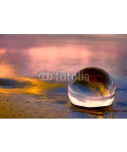 Alaskajade, Summer sunset displayed through a transparnt glass ball on the beach sand