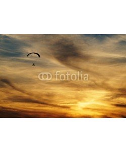am, Paragliding in clouds at sunset. Silhouette against a background a cloudy sky colors the sunset.