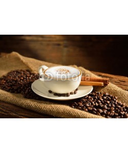 amenic181, A cup of cappuccino and coffee beans on old wooden background