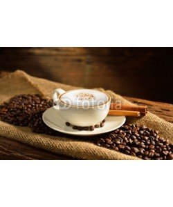 amenic181, A cup of cappuccino and coffee beans on old wooden background