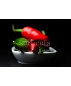 nanisimova, Cayenne pepper in white plate on dark background close up