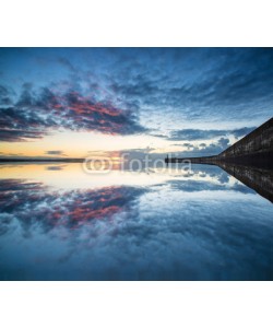 veneratio, Beautiful vibrant sunrise sky over calm water ocean with lightho